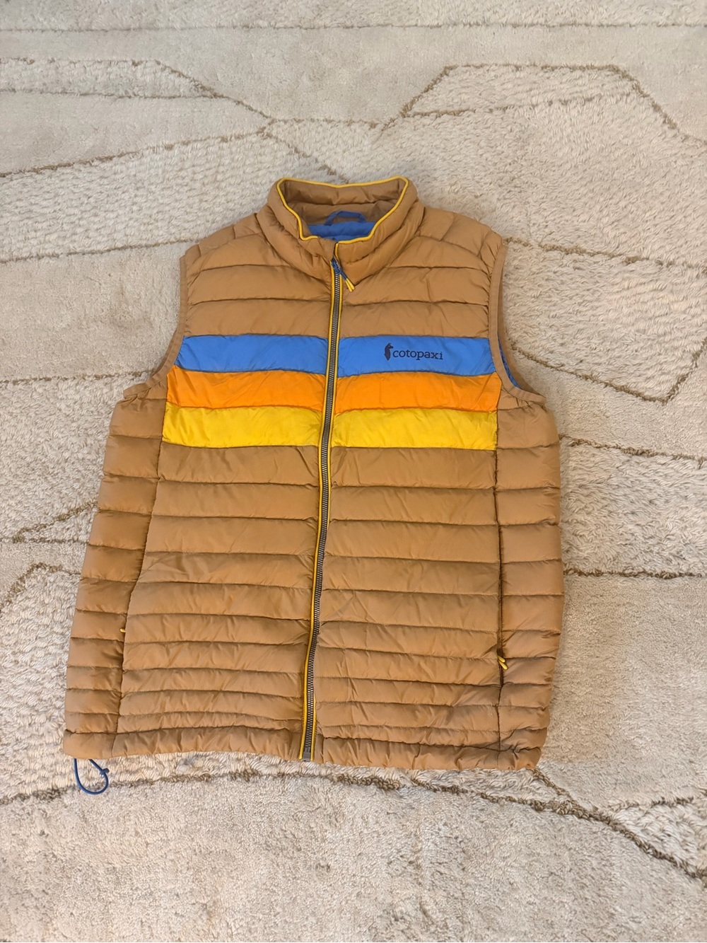 Cotopaxi Men's  Fuego Tan Puffer Vest with Blue, Orange & Yellow Stripes